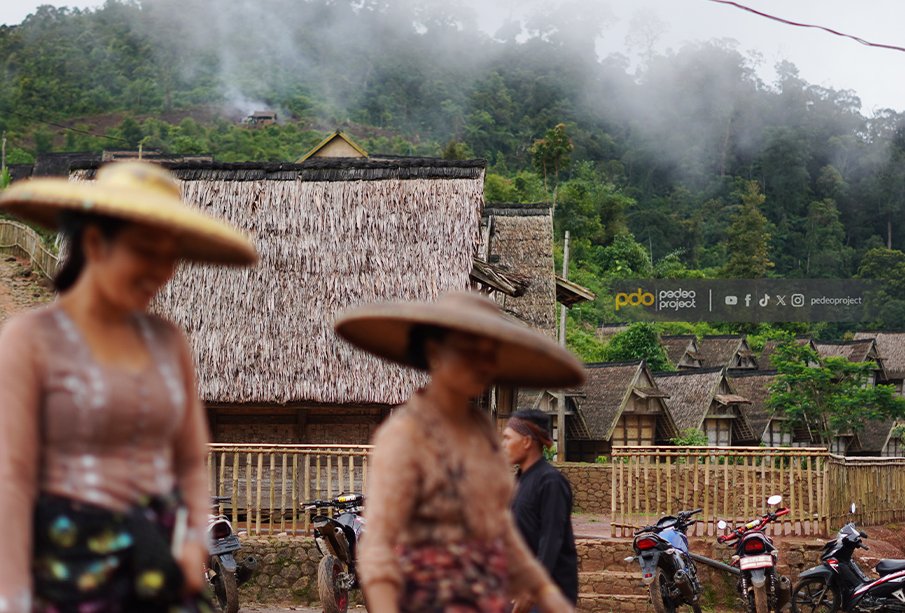 Warga Kasepuhan melintasi lumbung padi. Foto: Denny Raka/Pedeo Project