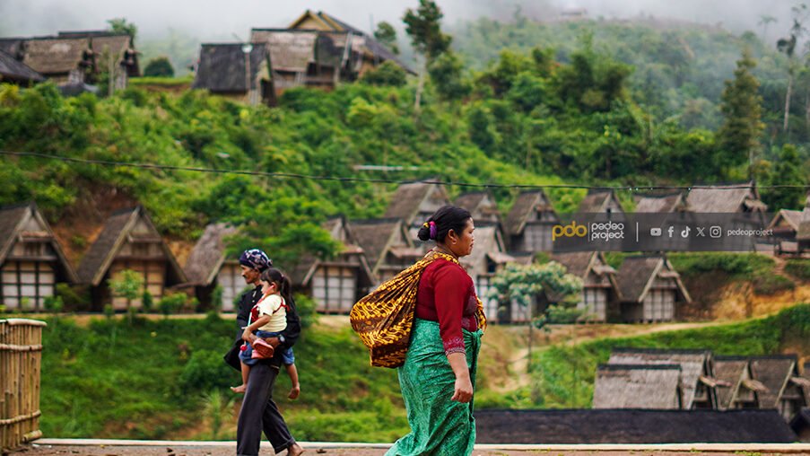 Warga Kasepuhan melintasi lumbung padi. Foto: Denny Raka/Pedeo Project