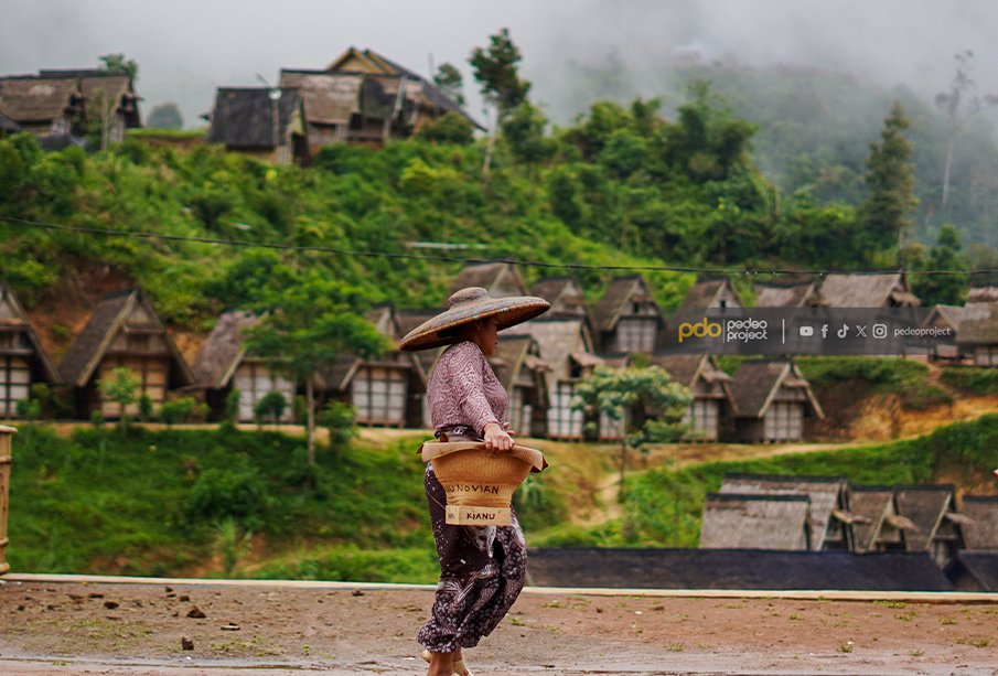 Warga Kasepuhan melintasi lumbung padi. Foto: Denny Raka/Pedeo Project